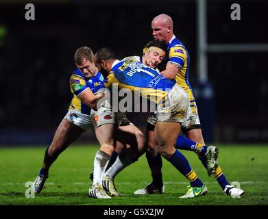 Andrew Dixon von Salford City Reds wird während des Super League-Spiels in Headingley Carnegie, Leeds Rhinos' Paul McShane (links), Jamie Jones-Buchanan und Richard Moore (rechts) in Angriff genommen. Stockfoto