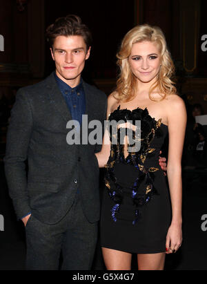 Pixie Lott kommt mit ihrem Freund Oliver Cheshire zur Julien Macdonald Herbst/Winter 2013 Laufsteg Show am zweiten Tag der London Fashion Week in Goldsmith's Hall, London. Stockfoto