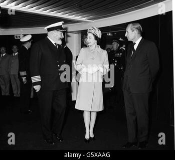 Die Königin und Kapitän Bill Warwick, der Meister der QE2, auf der Schiffsbrücke während der Tour Ihrer Majestät durch das Schiff. Stockfoto