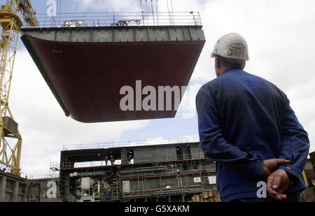 Arbeiter auf der Werft Alstom Chantiers de L'Atlantique in Saint Nazaire, Bretagne, Frankreich, beobachten, wie die Kielverlegung auf der Queen Mary 2 stattfindet. * die Zeremonie markiert den symbolischen Beginn des Baus des 1.132 Fuß langen Schiffes, das 200 Fuß über der Wasserlinie ragen wird, die am 14. Januar 2004 die erste Reise von Southampton nach Fort Lauderdale machen wird. Stockfoto