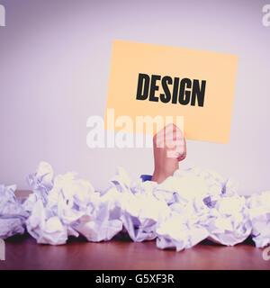 HAND MIT GELBEM PAPIER MIT DESIGNCONCEPT Stockfoto