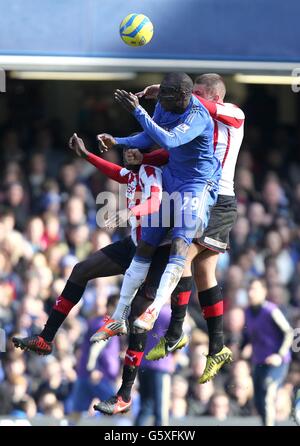 Fußball - FA Cup - vierte Runde Replay - Chelsea gegen Brentford - Stamford Bridge. Chelseas Demba Ba (Mitte) und Brentfords Jake Bidwell (rechts) kämpfen um den Ball in der Luft Stockfoto