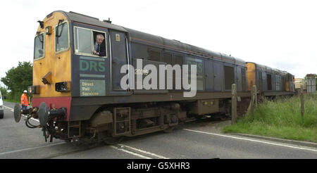 Der Zug mit einem leeren Kernkolben, der am Dienstag, den 11. Juni 2002 zusammenprallte, mit einem Lastwagen auf einem Bahnübergang in Kent, bewegt sich nach Untersuchungen des Unfalls. *die britische Verkehrspolizei sagte, dass der 50 Tonnen schwere Stahlkolben nicht beschädigt wurde und es keine Gefahr für die Öffentlichkeit gab, nachdem der Zug um 8.40 Uhr mit einem 40 Fuß langen Tieflader auf dem Bahnübergang Brenzett in Brookland, in der Nähe von New Romney, kollidierte. Der Kolben war von Willesden Zughof im Norden Londons abgeholt worden und wurde nach Dungeness, EINEM Atomkraftwerk, transportiert, wo er mit bis zu fünf gefüllt werden sollte Stockfoto