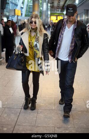 Singer Fergie (Stacy Ann Ferguson) kommt mit Ehemann Josh Duhamel am Terminal 5 des Flughafens Heathrow an. Stockfoto