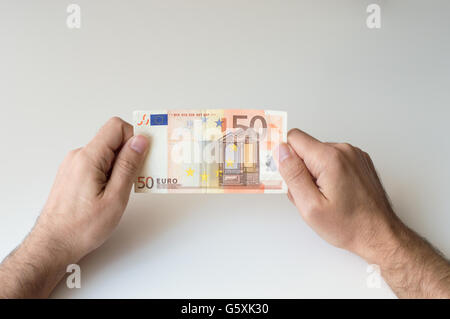 Mann, der 50 Euro-Banknote in seinen Händen hält Stockfoto