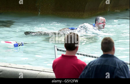 Ein englischer Fußballfan schwimmt im Pool eines Brunnens auf dem Trafalgar Square im Zentrum von London, obwohl er bei den Viertelfinalen der Weltmeisterschaft gegen Brasilien verloren hatte. * das Spiel, das im japanischen Stadion ecopa in Shizuoka gespielt wurde, war das erste Mal, dass die beiden Teams bei der Weltmeisterschaft seit Brasiliens Niederlage 1-0 gegen England bei der mexikanischen Weltmeisterschaft 1970 zusammenkamen. Stockfoto