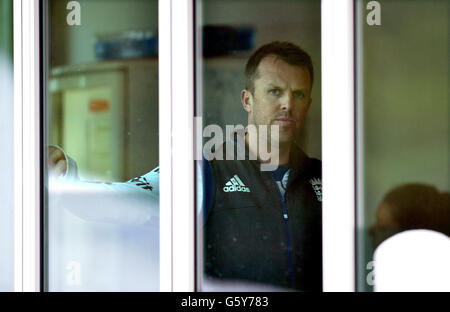 Englands verletzter Spin Bowler Graeme Swann schaut aus dem Umkleidekabinen-Fenster, während der erste Tag des ersten Tests an der University Oval, Dunedin, Neuseeland, mit Regenverzögerungen gespielt wird. Stockfoto