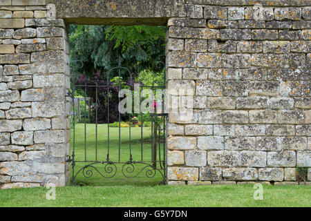 Dekorative schmiedeeiserne Tor im Cotswold Garten. Cotswolds, England Stockfoto