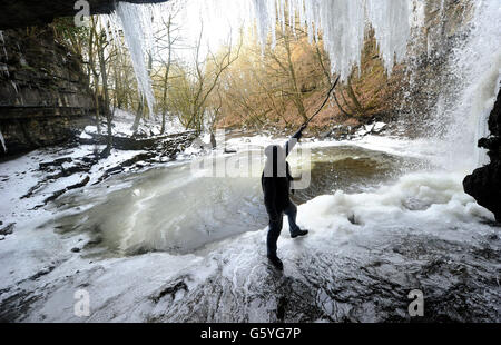 Bob Ripley, 62, aus Richmond schaut sich die Eiszapfen an, als der Bow Lee Beck in der Gibsons Cave in Teesdale im März ungewöhnlich friert, nachdem die Temperaturen gestern Abend auf minus sieben gesunken waren. Stockfoto