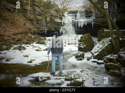 Bob Ripley, 62, aus Richmond schaut sich die Eiszapfen an, als der Bow Lee Beck in der Gibsons Cave in Teesdale im März ungewöhnlich friert, nachdem die Temperaturen gestern Abend auf minus sieben gesunken waren. Stockfoto