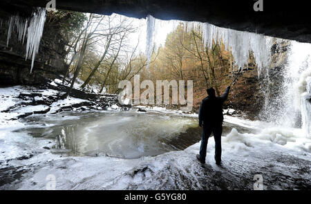 Bob Ripley, 62, aus Richmond schaut sich die Eiszapfen an, als der Bow Lee Beck in der Gibsons Cave in Teesdale im März ungewöhnlich friert, nachdem die Temperaturen gestern Abend auf minus sieben gesunken waren. Stockfoto