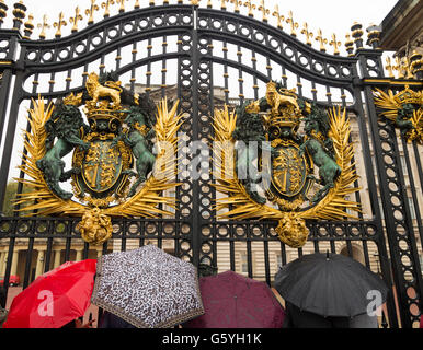 LONDON, ENGLAND - 21. Oktober 2015: Touristen auf der Suche durch ein Tor des Buckingham Palace an einem regnerischen Tag. Der Buckingham Palace ist Stockfoto