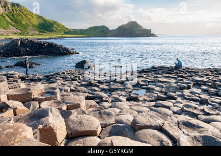 Touristen fotografieren auf Giants Causeway, einzigartige sechseckige Gesteinsformationen vulkanischen Basalt Felsen in Nordirland Stockfoto