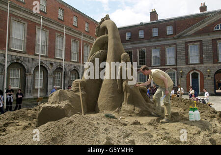 Daniel Doyle arbeitet an einer der größten Sandskulpturen, die jemals in Irland im Dublin Castle, der Republik Irland, hergestellt wurden. Herr Doyle ist Mitglied der Künstlergruppe Duthain Dealbh mit zwei weiteren Absolventen der bildenden Kunst, die sich seit zehn Jahren mit Sandskulpturen beschäftigt und in der ganzen Welt ausgestellt hat. Stockfoto