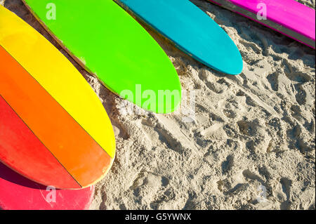 Gay Pride Regenbogen Farbe aufstehen Paddel langes Brett Surfbretter Rest zusammen am Strand in Rio De Janeiro, Brasilien Stockfoto