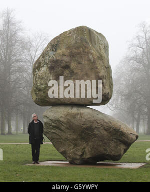 Der Künstler Peter Fischli steht neben seiner großformatigen Boulderskulptur 'Rock on Top of Another Rock', die das Künstlerduo Fischli/Weiss bei der Enthüllung in der Serpentine Gallery im Hyde Park, London, gezeigt hat. Stockfoto