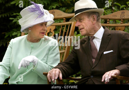 Königin Elizabeth II und der Herzog von Edinburgh unterhalten sich während einer musikalischen Aufführung in den Abbey Gardens, Bury St Edmunds während ihres Golden Jubilee-Besuches in Suffolk. *09/10/03: Die Queen, begleitet vom Herzog von Edinburgh, startete eine Reihe von modernisierten Zugwagen bei einem Besuch der Londoner Kings Cross Station. Die Great North Eastern Railway hat 30 Millionen in den Umbau aller 302 Pkw-Innenräume ihrer elektrischen 225-Flotte investiert. Zusätzliche Beinfreiheit für Passagiere in Standardunterkünften, Sitze mit besserer Rückenstütze, Kaffee-Zubereitungsmöglichkeiten und Strom Stockfoto