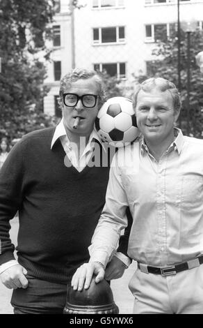 Schauspieler Michael Caine, Left, und Fußballer Bobby Moore am Leicester Square, London. Später in der Woche treffen sie sich zur Charity-Premiere von Escape to Victory am Donnerstag im Odeon. Das Duo tritt als alliierte Kriegsgefangene auf, die während des Zweiten Weltkriegs in einem deutschen Gefangenenlager interniert werden Der Film sieht sie als Teamkollegen in einer Fußballmannschaft aus alliierten Kriegsgefangenen, die von einer deutschen Seite zu einem Ausstellungsspiel herausgefordert werden. Stockfoto