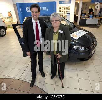 Ed Miliband, Vorsitzender der Labour Party und Abgeordneter von Doncaster North, präsentiert Shirley Lynam, die Wahlurnin, mit ihrem neuen Motability-Fahrzeug im Autohaus von Hayselden Volkswagen in Doncaster, Yorkshire. Stockfoto