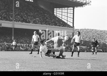 Martin Buchan von Manchester United lässt sich während eines League One-Spiels in Highbury gegen Arsenals Alan Sunderland absetzen. Auf der anderen Seite sehen wir die Manchester United Spieler Brian Greenhoff (links) und Lou Macari. Stockfoto