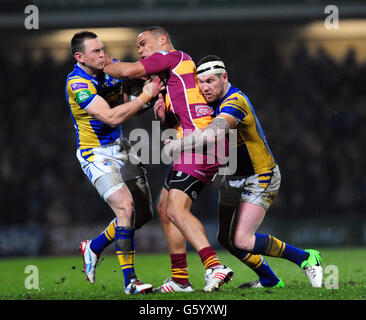 Huddersfield Giants' Leroy Cudjoe wird von Leeds Rhinos' Kevin Sinfield (links) und Brett Delaney während des Super League Spiels in Headingley Carnegie, Leeds, angegangen. Stockfoto