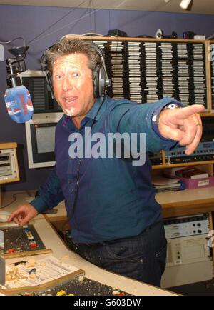 Capital Radio DJ Dr. Fox zeigt auf die Jenny Frost von Atomic Kitten nach ihrem Kuchenkampf im Capital Radio Studio am Londoner Leicester Square. * Fox wurde von den Mitgliedern der Mädchenband anlässlich des 9. Jahrestages der Pepsi Chart Show von Fox mit einem Kuchen überreicht. Die Show ist ein Single Chart Countdown für unabhängige Radiosender. Stockfoto