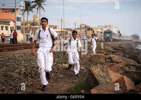 Schüler laufen, um den Zug entlang des Indischen Ozeans in Colombo, Sri Lanka Stockfoto