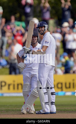 Jonathan Trott (links), Englands, lächelt, als Steven Finn feiert, dass er am fünften Tag des ersten Tests am University Oval in Dunedin, Neuseeland, seine ersten 50 Punkte nicht herausholen konnte. Stockfoto