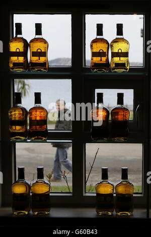 Ein Mann geht am Schaufenster der Jura Whisky Brennerei auf der schottischen Insel Jura vorbei. Master Blender aus der ganzen Welt treffen sich nächsten Monat in Schottland auf der Suche nach dem besten Whisky des Jahres. Stockfoto