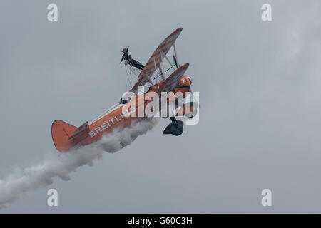 Breitling Wingwalker Doppeldecker Kunstflug mit einer Frau zu Fuß auf die Flügel des Flugzeugs zu tun Stockfoto