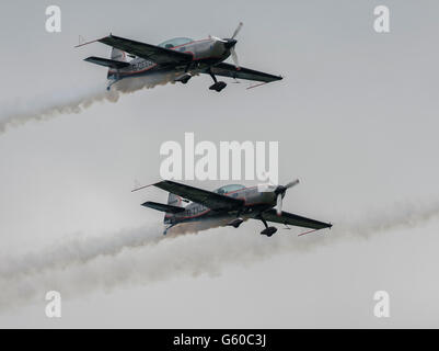 Zwei Ebenen von der klingen Aerobatic Anzeige Mannschaft mit weißen fliegen Rauchen Wege in den Himmel über Biggin Hill Air Show Stockfoto