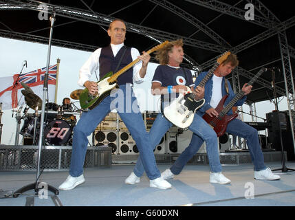 Status Quo spielen für Fans und Segler an Bord der HMS Ark Royal in Portsmouth. Die Band inszenierte das Konzert, um ihr neues Album Heavy Traffic zu promoten. Stockfoto