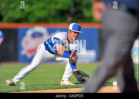 High School shortstop Fielding eine Kugel auf dem outfield Gras, bevor die erste Basis. USA. Stockfoto