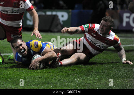 Leeds Rhinos' Joel Moon (links) feiert, als er einen Versuch unter Druck von Josh Charnley (rechts) von Wigan Warriors während des Stobart Super League-Spiels im Headingley Carnegie Stadium, Leeds, macht. Stockfoto