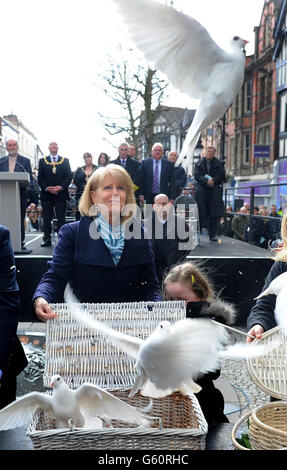 Wendy Parry, die Mutter von Tim Parry, lässt Tauben mit der Nichte Evie Parry-Fields während einer Zeremonie anlässlich des 20-jährigen Jubiläums der Warrington Bombe, Bridge Street, Warrington, frei. Stockfoto