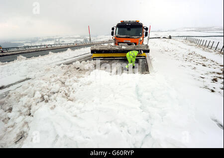 Ein Schneepflug räumt die A66 in der Nähe von Bowes, wo die Straße wegen starken Schnees für mehrere Stunden gesperrt war, da die Prognostiker gewarnt haben, dass ein weiterer Kälteeinbruch auf dem Weg ist - mit Teilen des Landes mit mehr Schnee und eisigen Temperaturen. Stockfoto