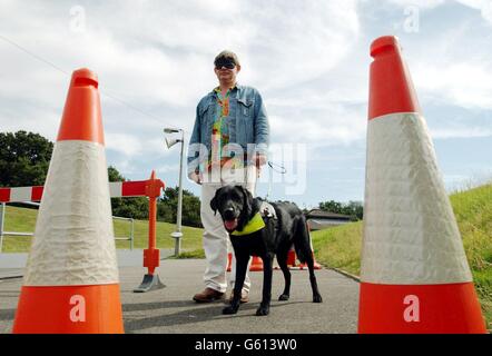 Schauspieler Martin Clunes wird von Buster, einem 18 Monate alten labrador-Cross-Retriever, um einen Hindernisparcours im Ausbildungszentrum Guide Dogs for the Blind Association in Woodford, Essex geführt. *Martin, die Stimme des TV-Zeichentrickhundes Merlin, besuchte das Zentrum, um sich einem echten Führerhund namens Merlin anzuschließen, der ebenfalls im Zentrum ausgebildet wird. Stockfoto