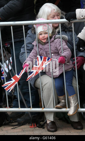 Ein Kind hält einige Flaggen, als sie die Ankunft der Herzogin von Cambridge und des Duke of Cambridge erwartet, bei BAE Systems in Barrow-in-Furness, Cumbria. Stockfoto