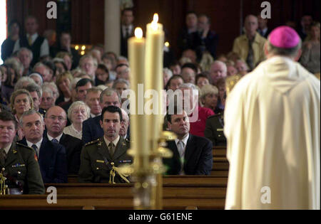 Die irische Premierministerin Bertie Ahern (vorne links, nicht in Uniform) hört die Messe, die Bischof Damien Field in der St. Mary's Pro-Cathedral in Dublin, Irland, zum ersten Jahrestag der Angriffe auf New York, Washington und Pennsylvania gibt. Stockfoto