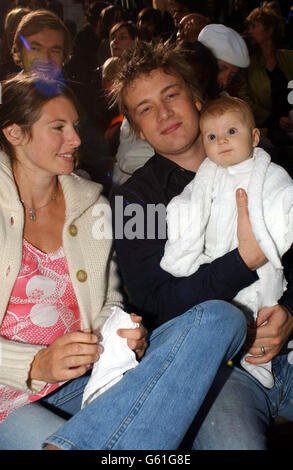 TV-Starkoch Jamie Oliver mit seiner Frau Jools und dem Baby Poppy Honey beim Betrachten der London Fashion Week Show von Frost French, dem Modehaus von Sadie Frost und Jemima French im Open Air Theatre im Regent's Park, London. Stockfoto