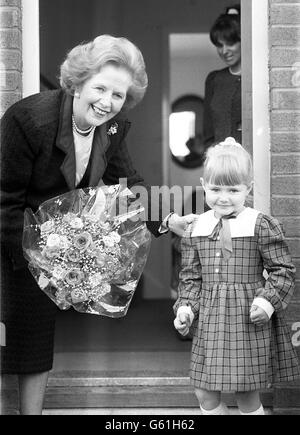 Die Premierministerin Margaret Thatcher überreicht die vierjährige Alex Gater den Kameras, nachdem sie während eines Besuchs im Elternhaus auf dem Wohnungsbau von St. Hildas in Middlesborough einen Blumenstrauß vom Kleinkind erhalten hatte. Stockfoto