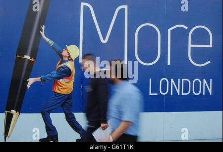 Fußgänger kommen Anfang September 2002 an einem Wandgemälde auf einem Horten um eine Baustelle in der City of London vorbei. * Neue Gebäude und Umbauten - sowohl für Anwohner als auch für Geschäftsleute - die sich vom Paddington Basin im Westen bis zu Canary Wharf im Osten erstrecken, bedeuten eine sich ständig verändernde Skyline in der Hauptstadt. Stockfoto