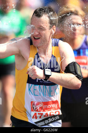 Läufer kühlen sich bei den heißen Temperaturen während des Virgin London Marathon in London ab. Stockfoto