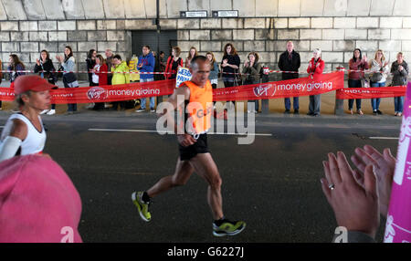 Die Fans stehen auf den Straßen, wenn die Läufer des London-Marathons teilnehmen Der Marathon macht sich auf den Weg in die Lower Thames Street Stockfoto