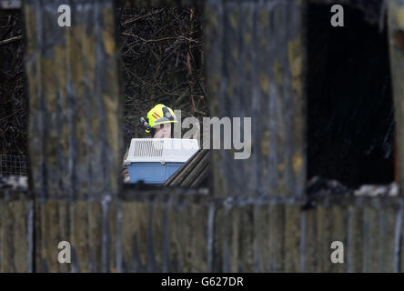 Ein Feuerwehrmann sieht die Schäden am Reptilienhaus im Five Sisters Zoo in Polbeth, West Calder. Stockfoto