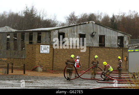 Feuerwehrleute sehen die Schäden am Reptilienhaus im Five Sisters Zoo in Polbeth, West Calder. Stockfoto