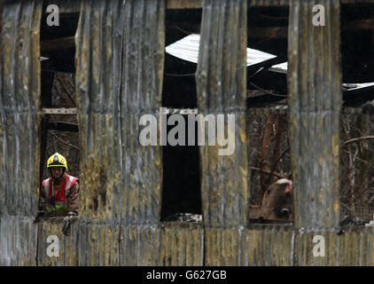 Ein Feuerwehrmann sieht die Schäden am Reptilienhaus im Five Sisters Zoo in Polbeth, West Calder. Stockfoto