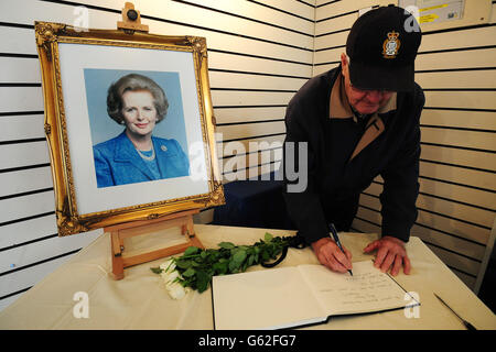 Ein Mitglied der Öffentlichkeit unterzeichnet ein Kondolenzbuch unter einem Porträt der ehemaligen Premierministerin Baroness Thatcher im Grantham Museum in ihrer Heimatstadt Grantham. Stockfoto