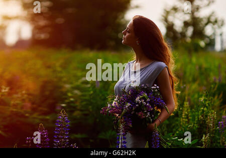 Frau mit einem Blumenstrauß blaue lupine Stockfoto