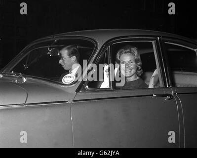 Ein attraktives Lächeln und eine Welle von Miss Katharine Worsley, während sie mit ihrem Verlobten, dem Herzog von Kent - am Steuer - zum Buckingham Palace fährt, um die Königin zu sehen. Stockfoto